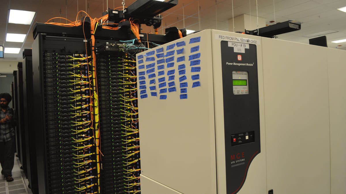 Data-center racks densely cross-connected with network cabling, illustrating the segmented enterprise networks that Cisco ISE governs.